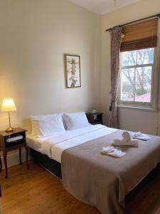 a bedroom with a large bed and a window at The Old Vic Hotel in Canowindra