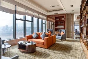 a living room with an orange couch and a table at Radisson Blu Plaza Chongqing in Chongqing