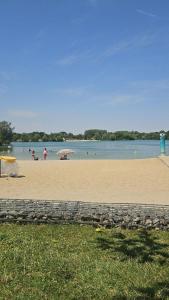 a beach with people in the water and umbrellas at Sérénité in Corquilleroy
