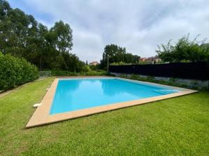 a large blue swimming pool in a yard at Casa Mamosteira Apartamento da Eira in Sandim