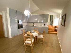 a kitchen and dining room with a table and chairs at Casa Mamosteira Apartamento da Eira in Sandim