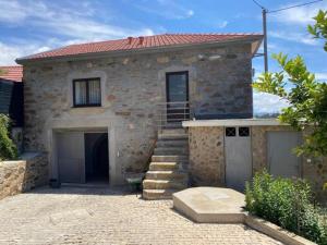 a stone house with a staircase in front of it at Casa Mamosteira Apartamento Refugio in Sandim