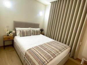a bedroom with a bed and a window with curtains at Casa Mamosteira Apartamento Refugio in Sandim +9 photos