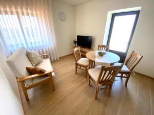 a living room with a table and chairs and a television at Casa Mamosteira Apartamento Refugio in Sandim