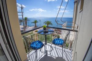 a balcony with a table and chairs and the ocean at Saronic View Studio in Agioi Theodoroi