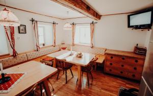 a dining room with a table and chairs and a tv at Stegerhütte in Hinterstoder