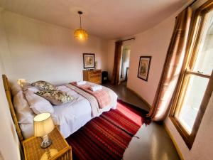 a bedroom with a bed and a window and a rug at Oudam Cottage in Carnarvon