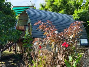 a small house with a blue roof and some flowers at Fortunate Lodge, Restaurant & Bar in Lénakel