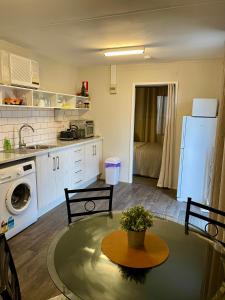 a kitchen with a table and a sink and a refrigerator at Murray Bridge Riverview cabin in Murray Bridge