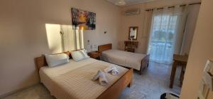 a small bedroom with two beds and a window at K SANTIS STUDIOS in Pefki