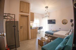 a bedroom with a bed and a couch and a kitchen at Saronic View Studio in Agioi Theodoroi