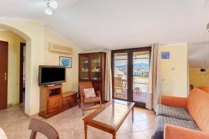 a living room with a couch and a tv at Attico Bella Vista in Siniscola