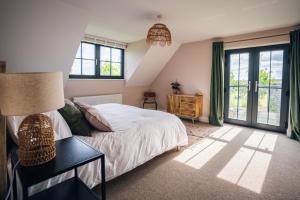 a bedroom with a bed and a table with a lamp at Mill Farm in Gamlingay