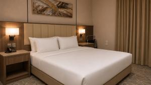 a large white bed in a hotel room at NARS Plus Serviced Apartments - Al Nuzha in Jeddah