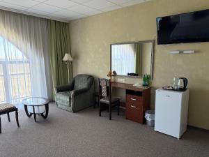 a hotel room with a chair a desk and a mirror at Смак Бажання in Sebino