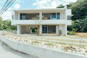 a white house with rocks in front of it at MANANI - Vacation STAY 16612v in Nago