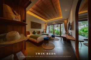a hotel room with a bed and a desk and a room at ULU Valley Retreat in Tegalalang +38 photos