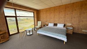 a bedroom with a bed and a large window at Смак Бажання in Sebino