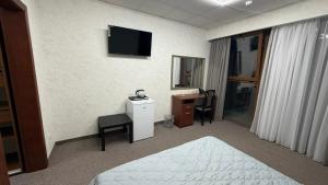 a hotel room with a bed and a desk and a television at Смак Бажання in Sebino +37 photos
