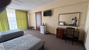a hotel room with two beds and a mirror and a person taking a picture at Смак Бажання in Sebino