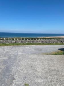 an empty parking lot with the ocean in the background at The Tackroom in Fanore