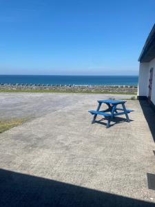 a blue picnic table sitting on the side of a building at The Tackroom in Fanore