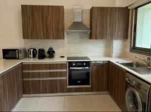 a kitchen with wooden cabinets and a stove top oven at Halcyon Central Apartments in Larnaca