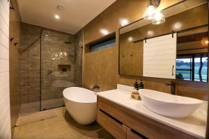 a bathroom with a tub and a sink and a shower at Senalala Safari Lodge in Klaserie Private Nature Reserve
