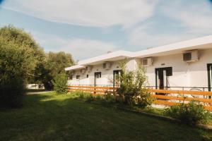 a white building with a fence in the yard at BOHOTEL Messonghi - Designer's Hotel in Mesongi