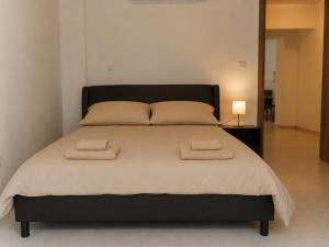 a bedroom with a large bed with two towels on it at Halcyon Central Apartments in Larnaca