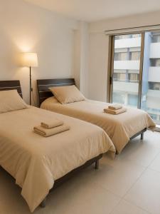 two beds sitting next to each other in a bedroom at Halcyon Central Apartments in Larnaca +29 photos
