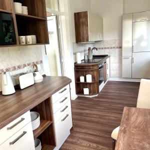 a kitchen with white cabinets and a wooden floor at Wellness-Oase-Nossen Kirchblick in Nossen