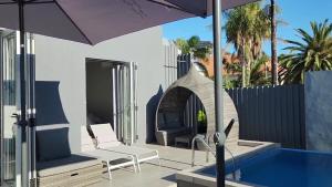 a patio with a swimming pool and an umbrella at Marble Blue in Cape Town