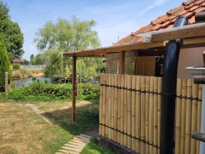 a fence in front of a house next to a river at Le nid de la mare in Mervans