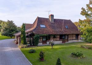 a large house with a green yard in front of it at Le nid de la mare in Mervans