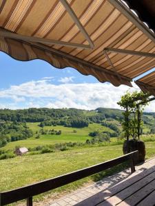 a wooden porch with a view of a green field at Cozy Winehouse - Remote Vineyard Escape in Podčetrtek