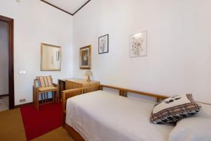 a bedroom with a bed and a chair in it at Casa Lele in Sarroch