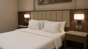 a bedroom with a large bed with white sheets and pillows at NARS Plus Serviced Apartments - Al Nuzha in Jeddah