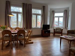 a living room with a table and chairs and a television at Dahmerhof in Dahme