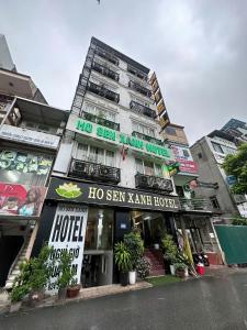 a building with a hotel on the side of the street at Hồ Sen Xanh Hotel Hà Nội in Hanoi