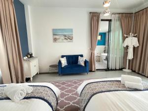 a hotel room with two beds and a blue chair at Romlaphass Boutique Villa in Kalasin +288 photos