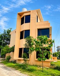 a yellow building with trees in front of it at The Nawab's Villa in Mānakpur