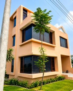 a orange building with a palm tree in front of it at The Nawab's Villa in Mānakpur