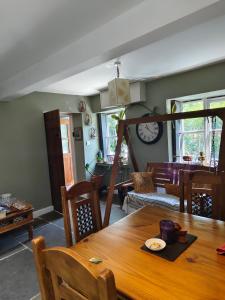 a dining room with a table and a living room at Tranquil Woodland Cottage by river Wye in Lydbrook +25 photos