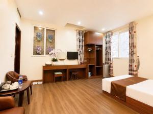 a hotel room with a bed and a desk at Hồ Sen Xanh Hotel Hà Nội in Hanoi