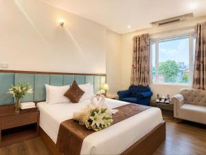 a hotel room with a bed and a chair at Hồ Sen Xanh Hotel Hà Nội in Hanoi +12 photos