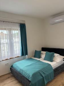 a bedroom with a bed with blue sheets and a window at WINE NOT Tállya in Tállya