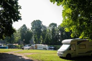 a camper van parked next to a marina with boats at Camping ZAMEK C1 in Giżycko