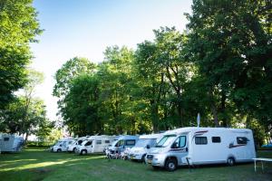 a row of white rvs parked in a field at Camping ZAMEK C1 in Giżycko +1 photo