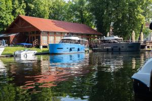 three boats are docked in front of a building at Camping ZAMEK C1 in Giżycko